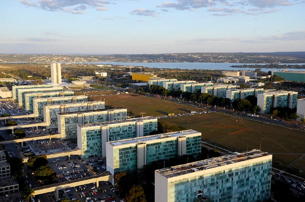 Vista aérea da Esplanada dos Ministérios em Brasília, com prédios governamentais alinhados.
